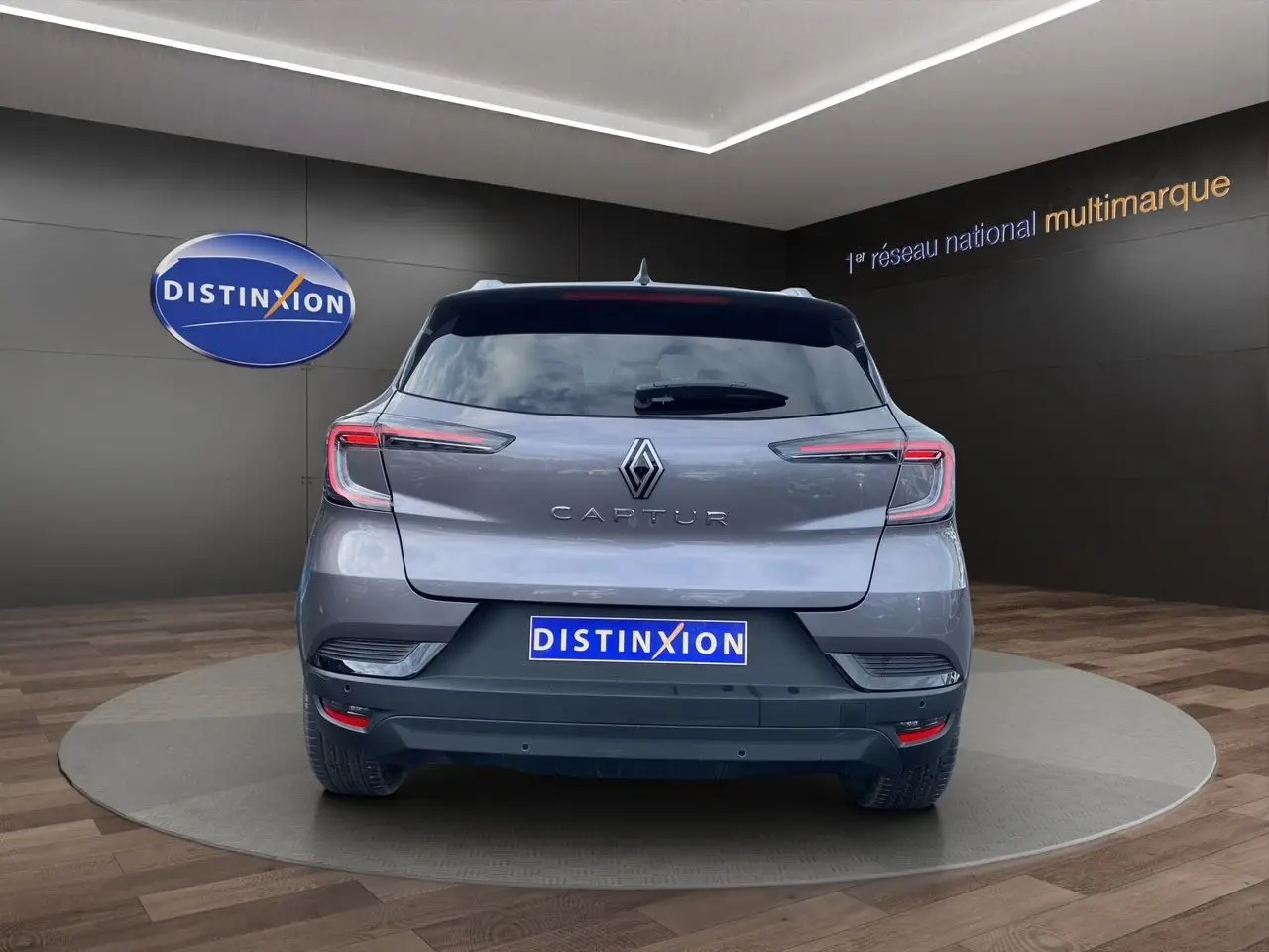 Vue arrière d'un Renault Captur gris Cassiopée avec toit noir, barres de toit et vitres arrière surteintées.