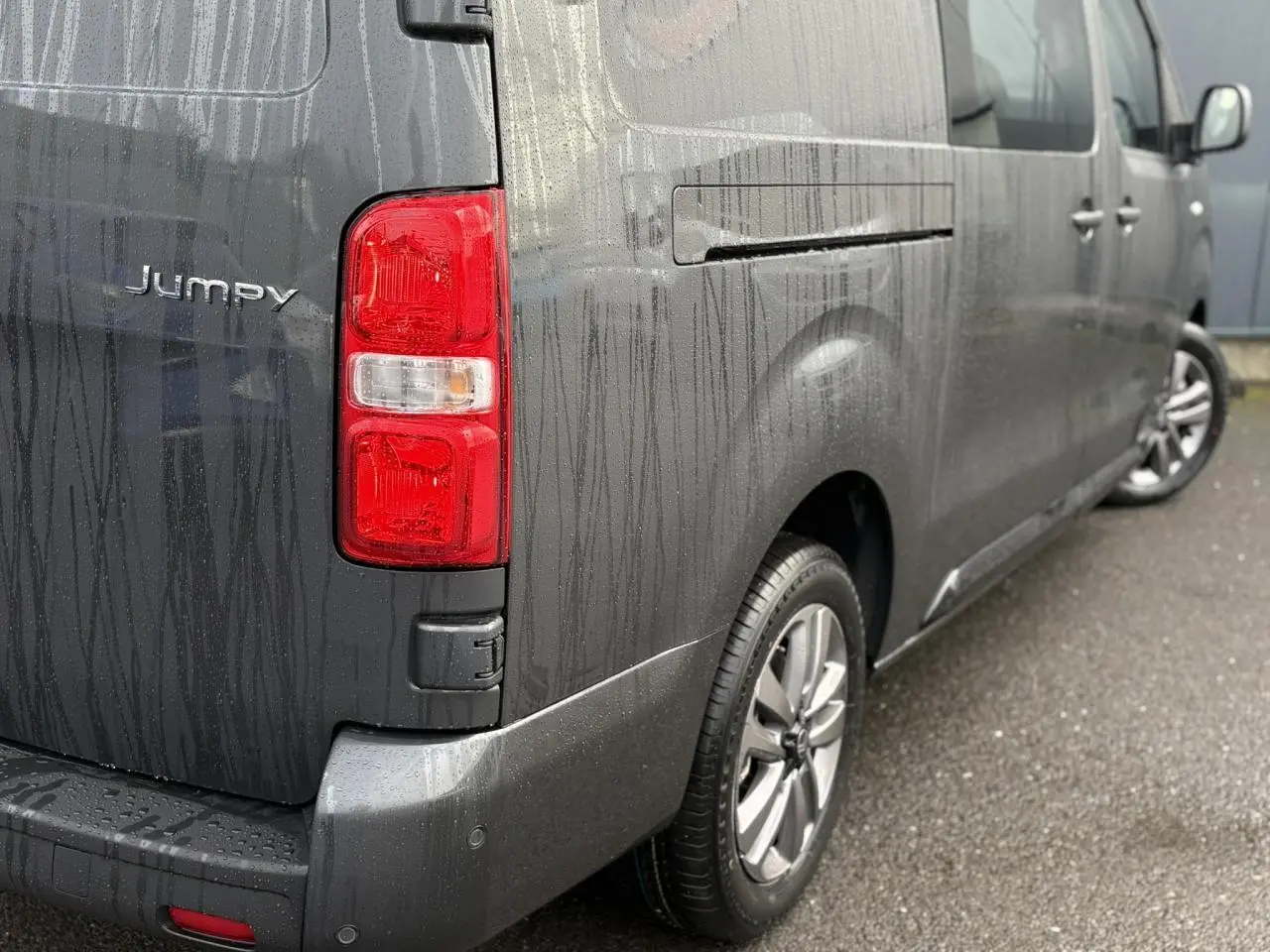 Vue 3/4 arrière droite d'un Citroën Jumpy XL gris titane avec jantes alliage 17'' et feux arrière rouges.