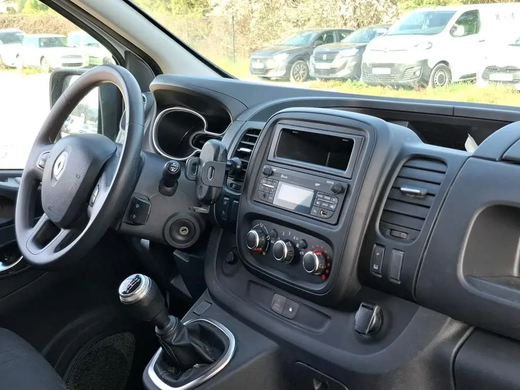 Vue intérieure côté conducteur du Renault Trafic Fourgon 2021, montrant le volant, la boîte manuelle et la console centrale noire.