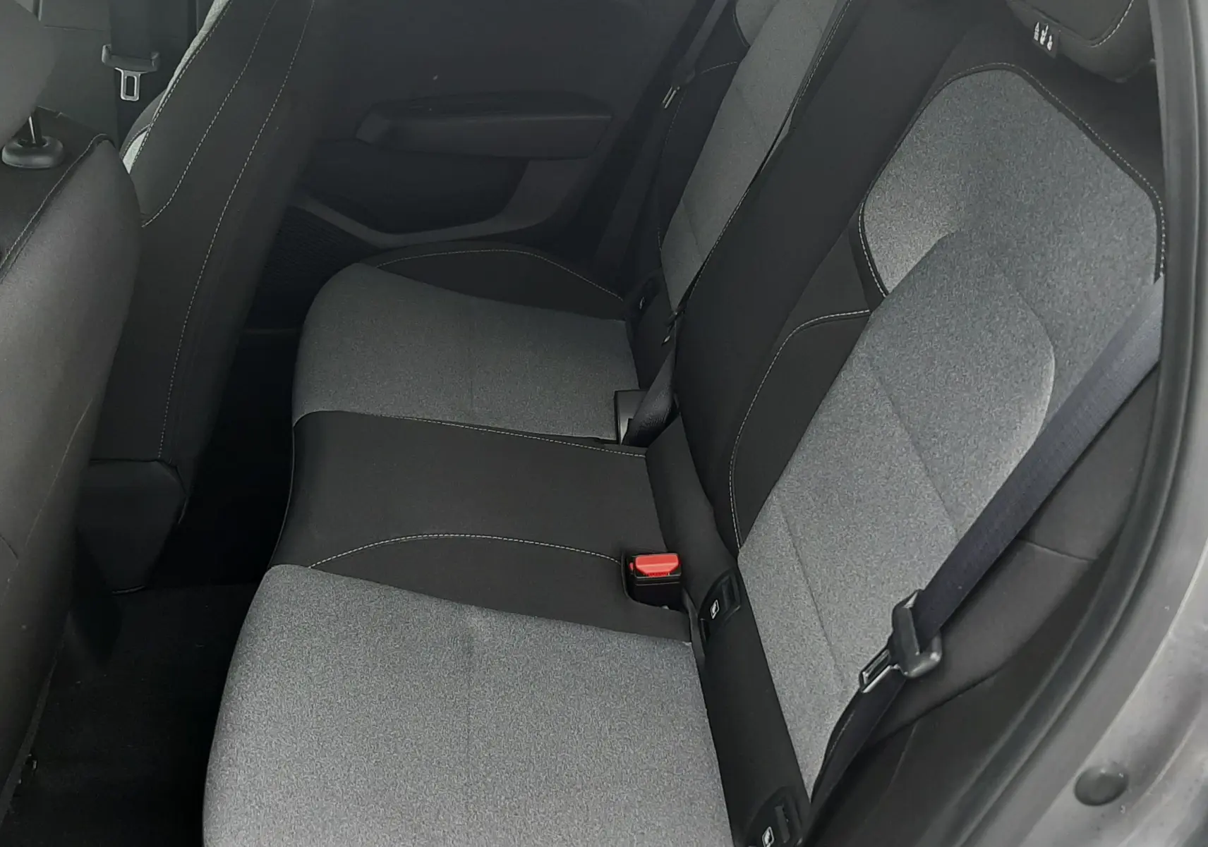 Vue intérieure côté droit des sièges arrière gris clair et noir de la Renault Clio V 2025, finition tissu bicolore.