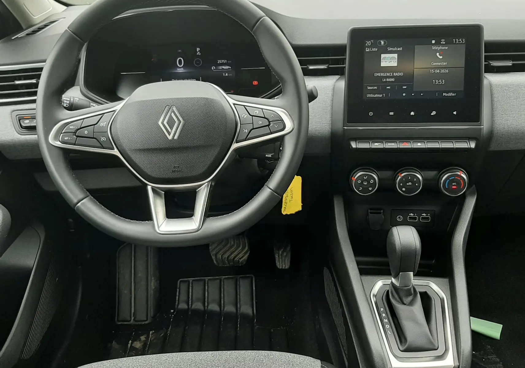 Vue intérieure avant de la Renault Clio V gris schiste, montrant le volant multifonction, l'écran tactile et la console centrale.