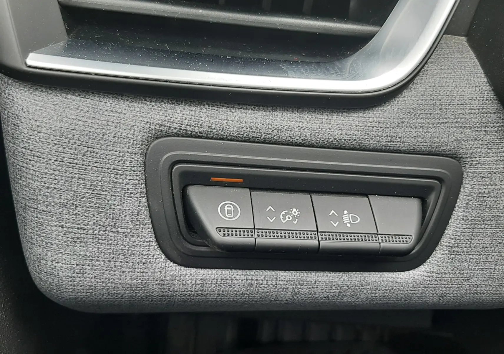 Détail intérieur du tableau de bord gris noir de la Renault Clio V, montrant les commandes d’éclairage et de verrouillage.