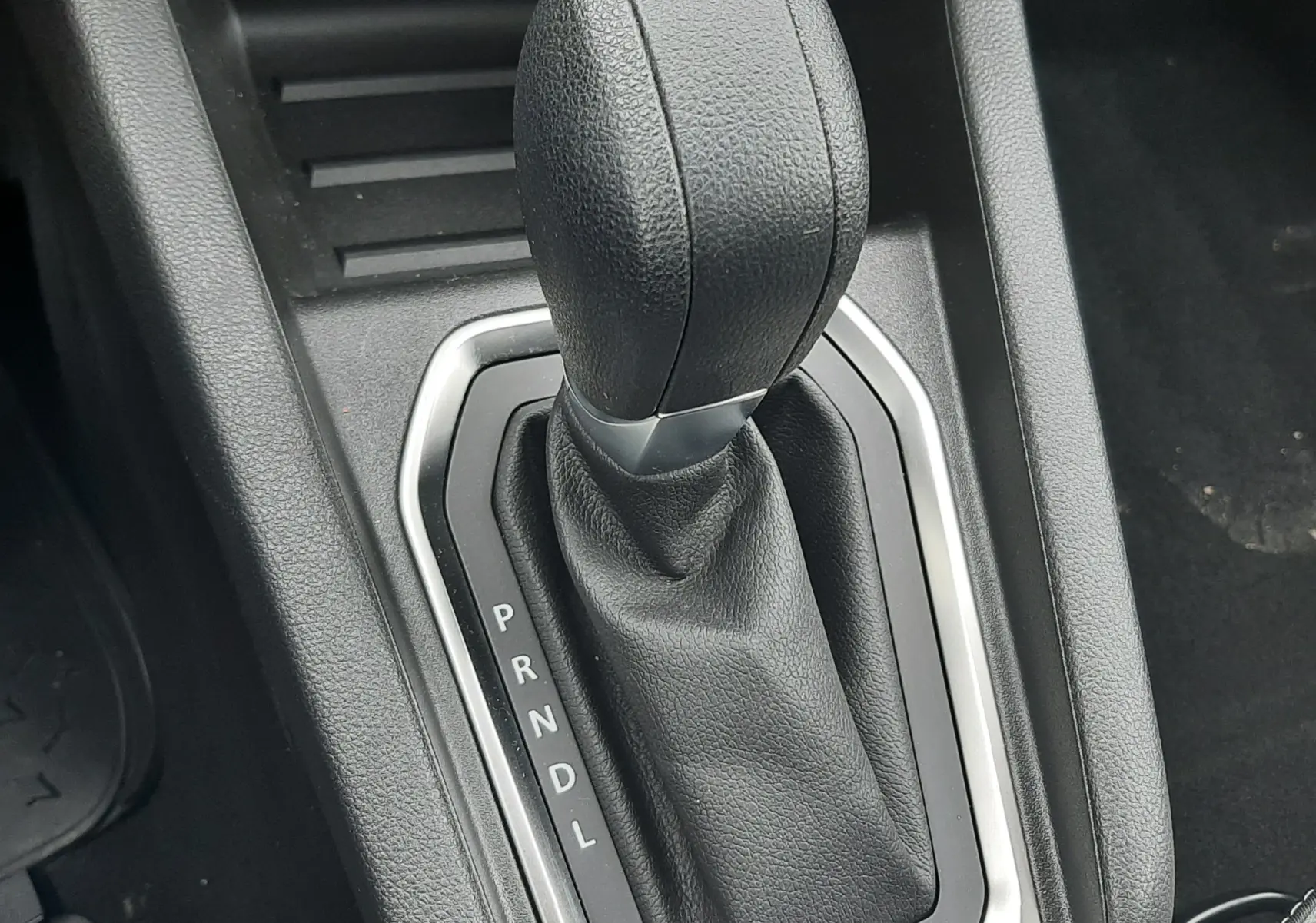 Gros plan sur le levier de vitesses automatique noir de la Renault Clio V 2025, entouré d’un contour argenté.