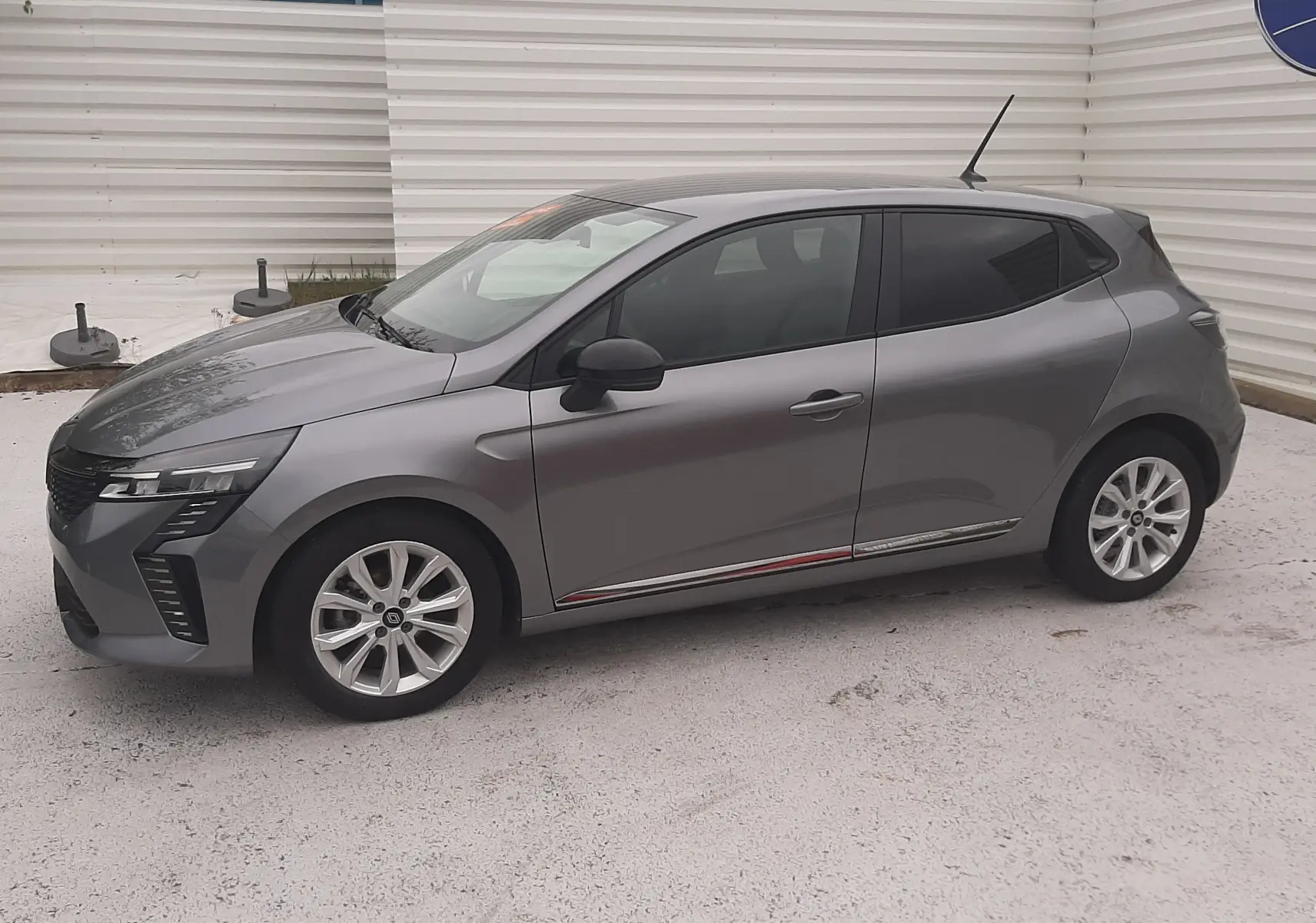 Renault Clio V gris schiste vue de profil côté gauche, avec jantes alliage et vitres teintées.
