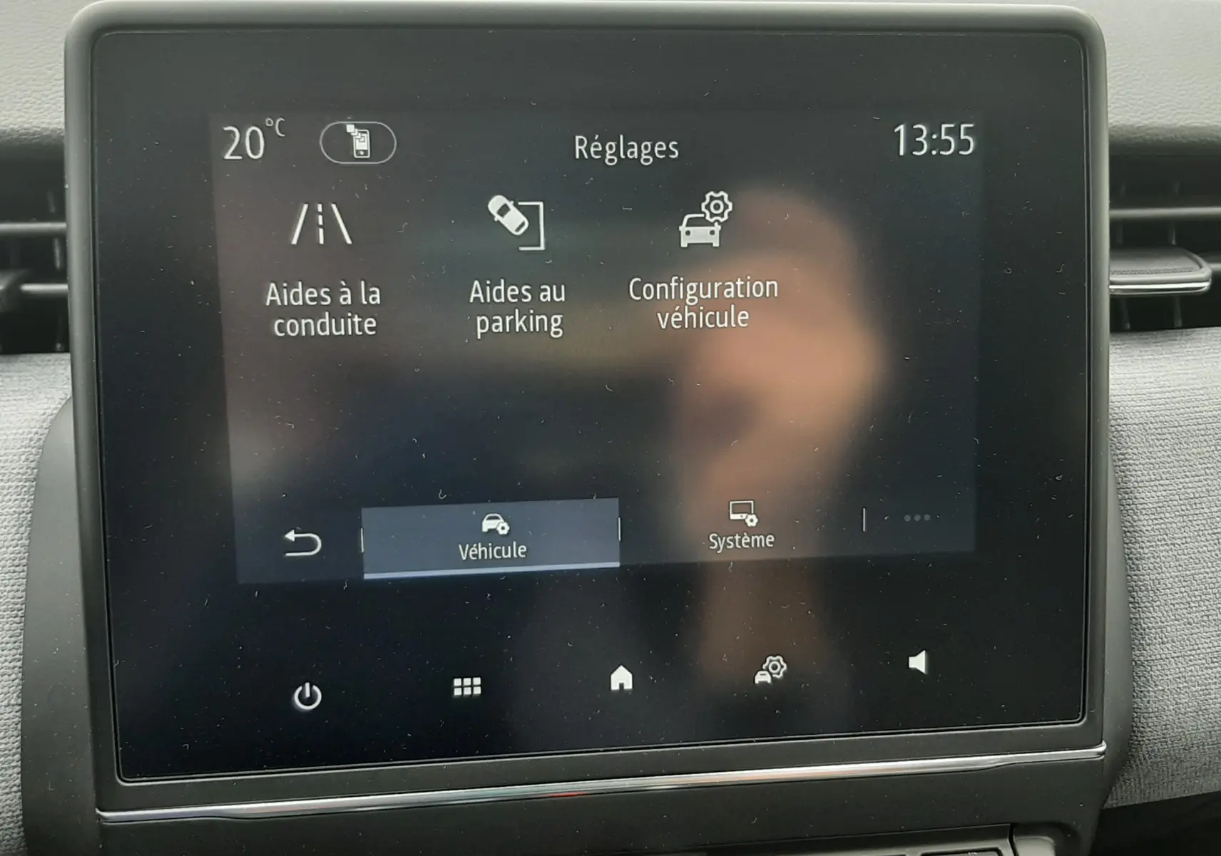 Écran tactile central du tableau de bord de la Renault Clio V gris schiste, affichant les réglages d’aides à la conduite et parking.