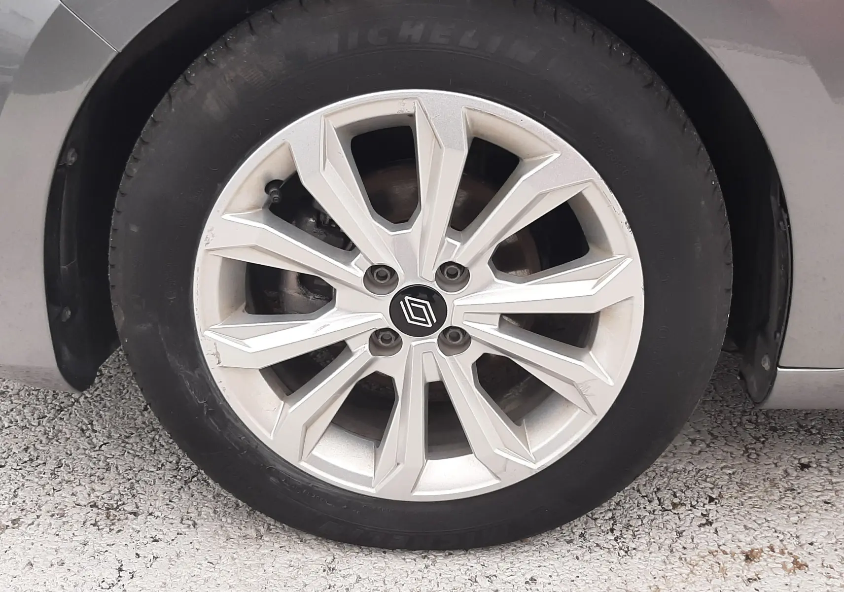 Gros plan sur la roue avant droite de la Renault Clio V gris schiste, avec jante alliage à design géométrique.