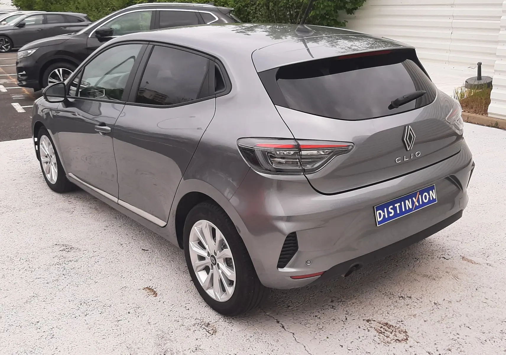 Vue 3/4 arrière droite d'une Renault Clio V gris schiste avec vitres teintées et jantes alliage 16 pouces.