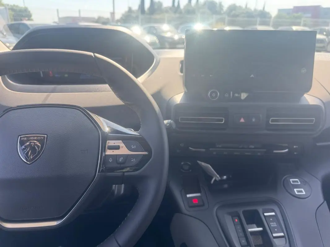 Vue intérieure du Peugeot Rifter 2026 montrant le volant multifonctions en cuir et l'écran tactile central.