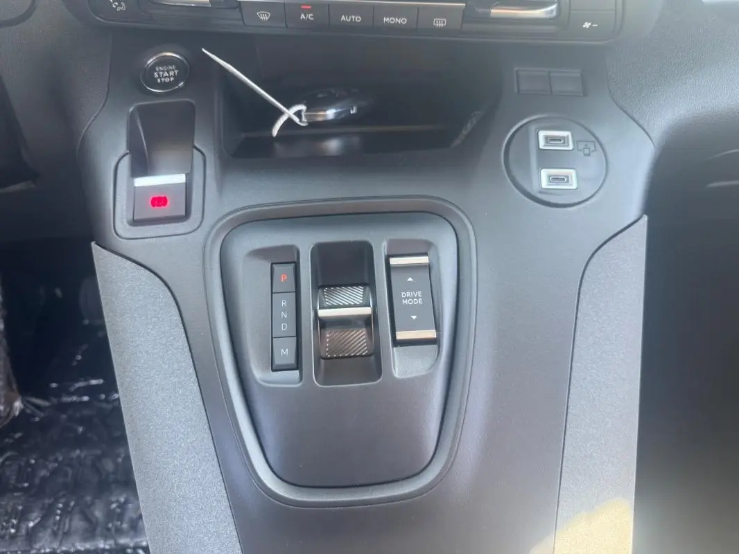 Gros plan sur la console centrale noire du Peugeot Rifter 2026 avec levier de vitesse automatique et boutons de mode de conduite.
