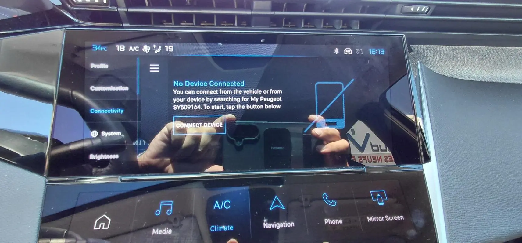 Écran tactile central du tableau de bord du Peugeot 408 Hybrid 2025, affichant le menu de connectivité.
