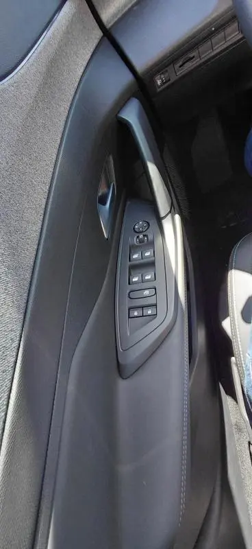 Vue rapprochée de la porte côté gauche noire du Peugeot 408 Hybrid 145 e-DCS6 Allure avec commandes électriques des vitres.
