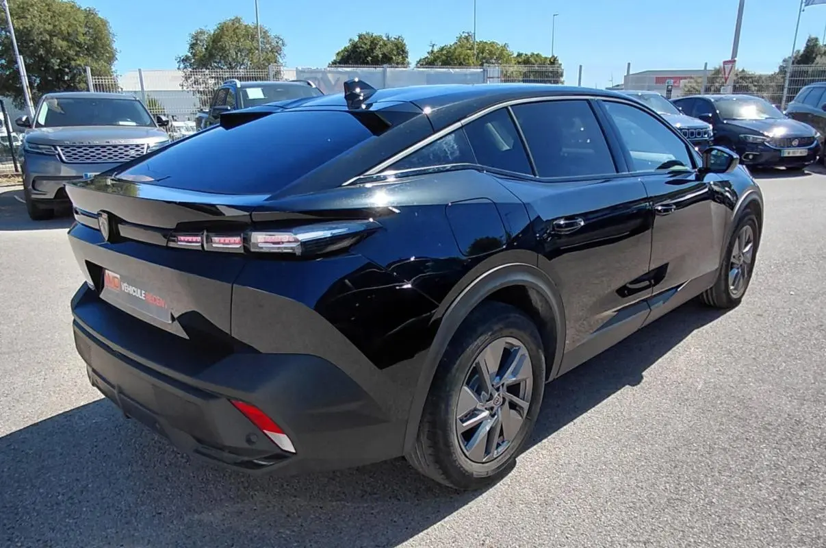 Peugeot 408 Hybrid 145 e-DCS6 Allure noir, vue 3/4 arrière droit, avec feux arrière LED distinctifs et jantes modernes.
