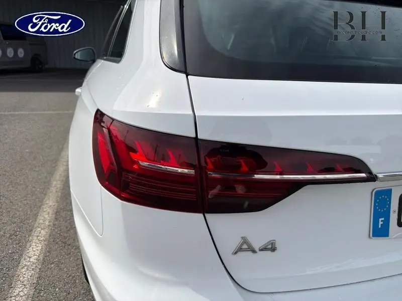 Gros plan sur l'arrière droit blanc glacier métallisé d'une Audi A4 Avant avec feux arrière LED distinctifs.