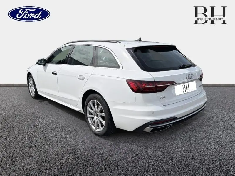 Audi A4 Avant blanc glacier métallisé vue 3/4 arrière droit avec jantes alu et feux LED distinctifs.