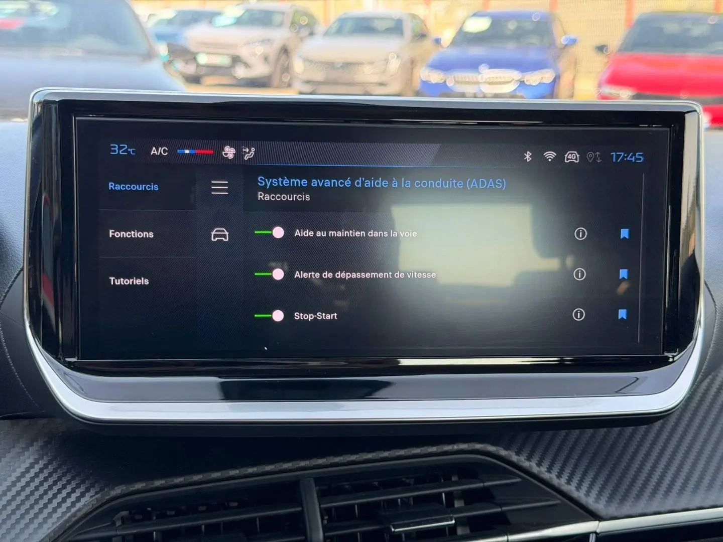 Écran tactile intérieur de la Peugeot 208 noir, affichant le menu d’aide à la conduite ADAS en journée.