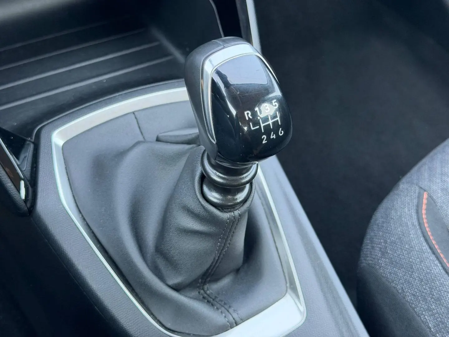 Le levier de vitesse manuel noir de la Peugeot 208 1.2 100ch Style vu en gros plan côté conducteur.