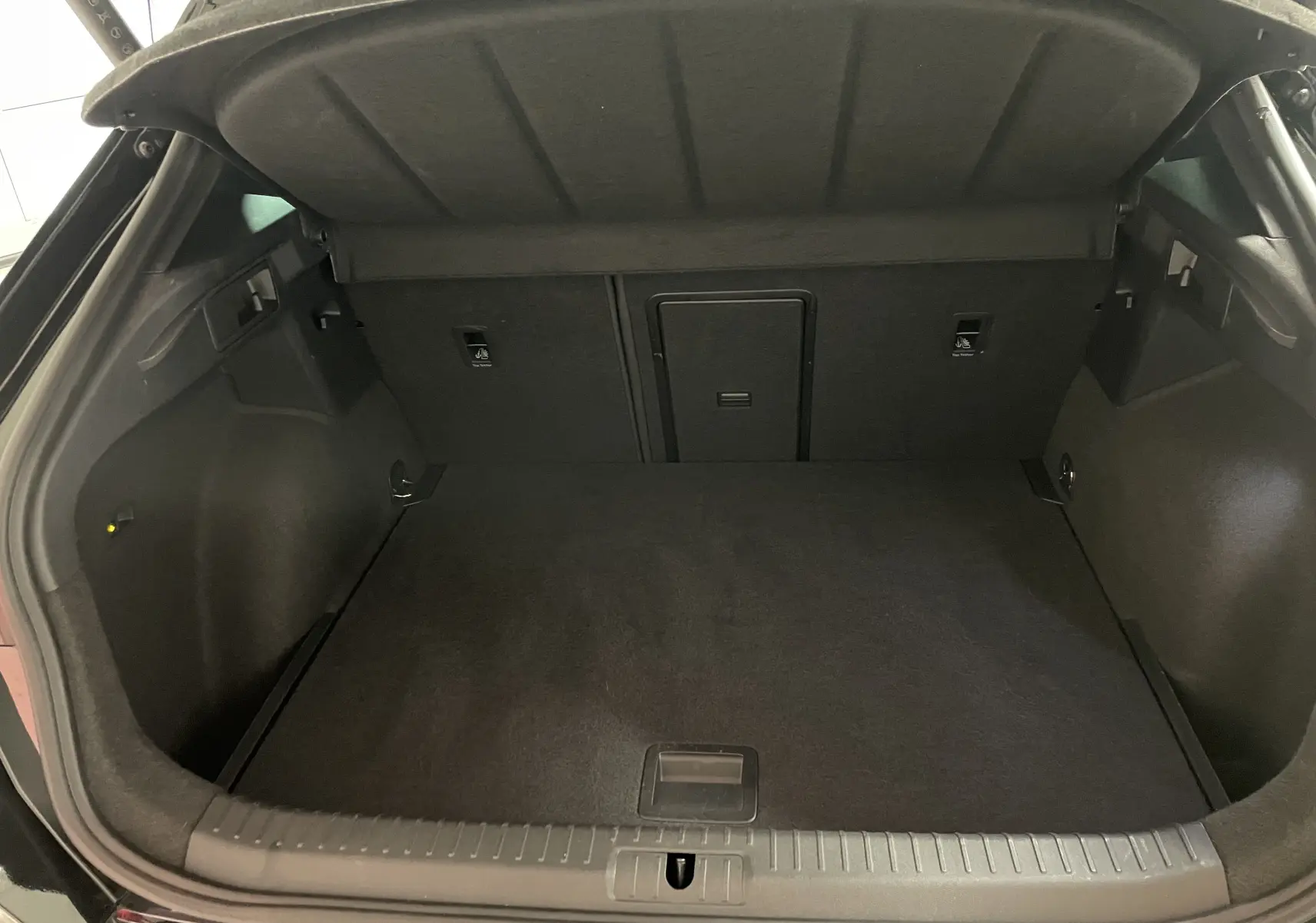 Coffre ouvert vu de l'arrière d'un CUPRA Formentor 2.0 TDI 150 DSG7 noir minuit, espace de chargement vide et propre.