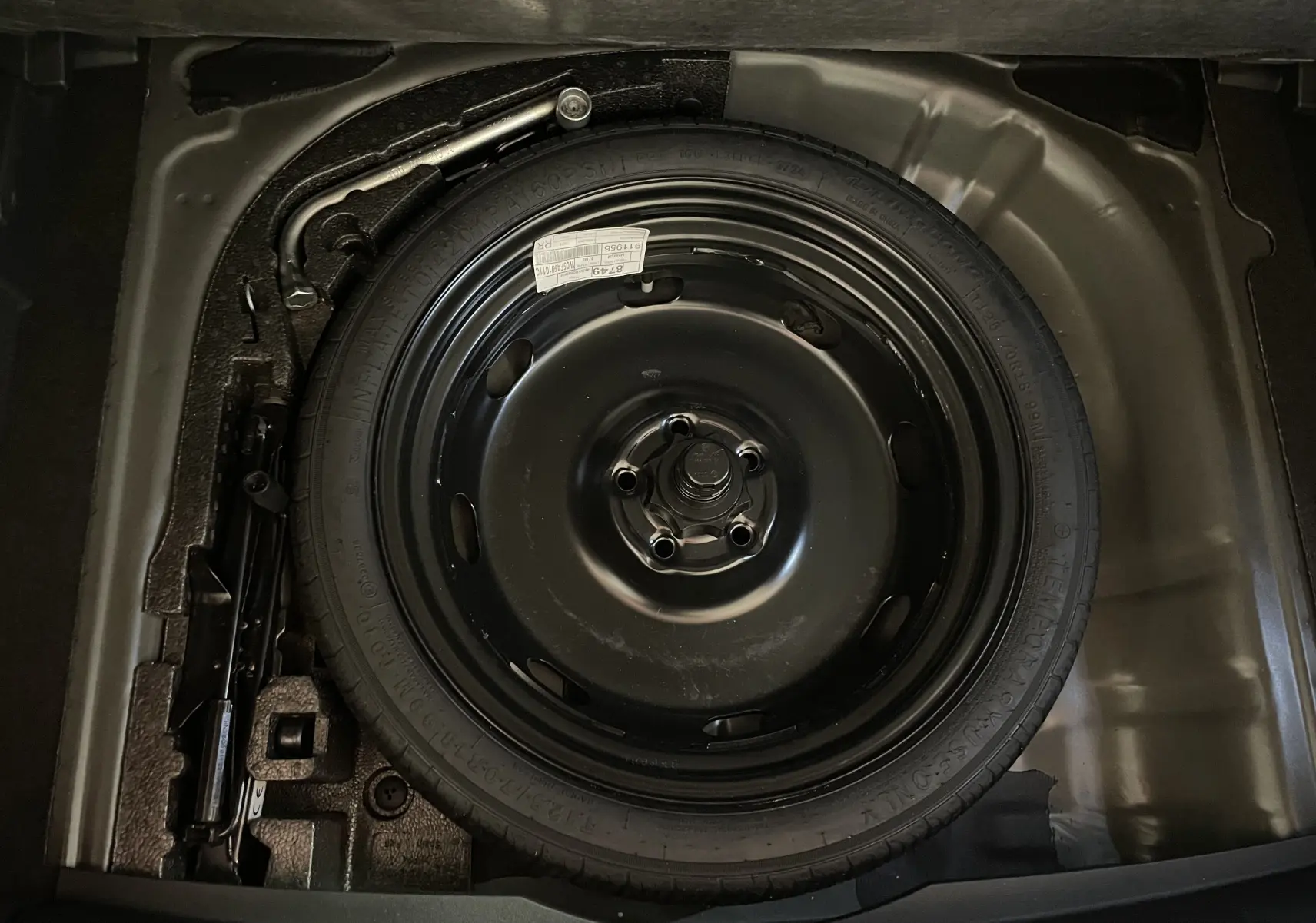 Gros plan sur la roue de secours compacte noire du coffre du CUPRA Formentor 2025 en peinture Noir Minuit.