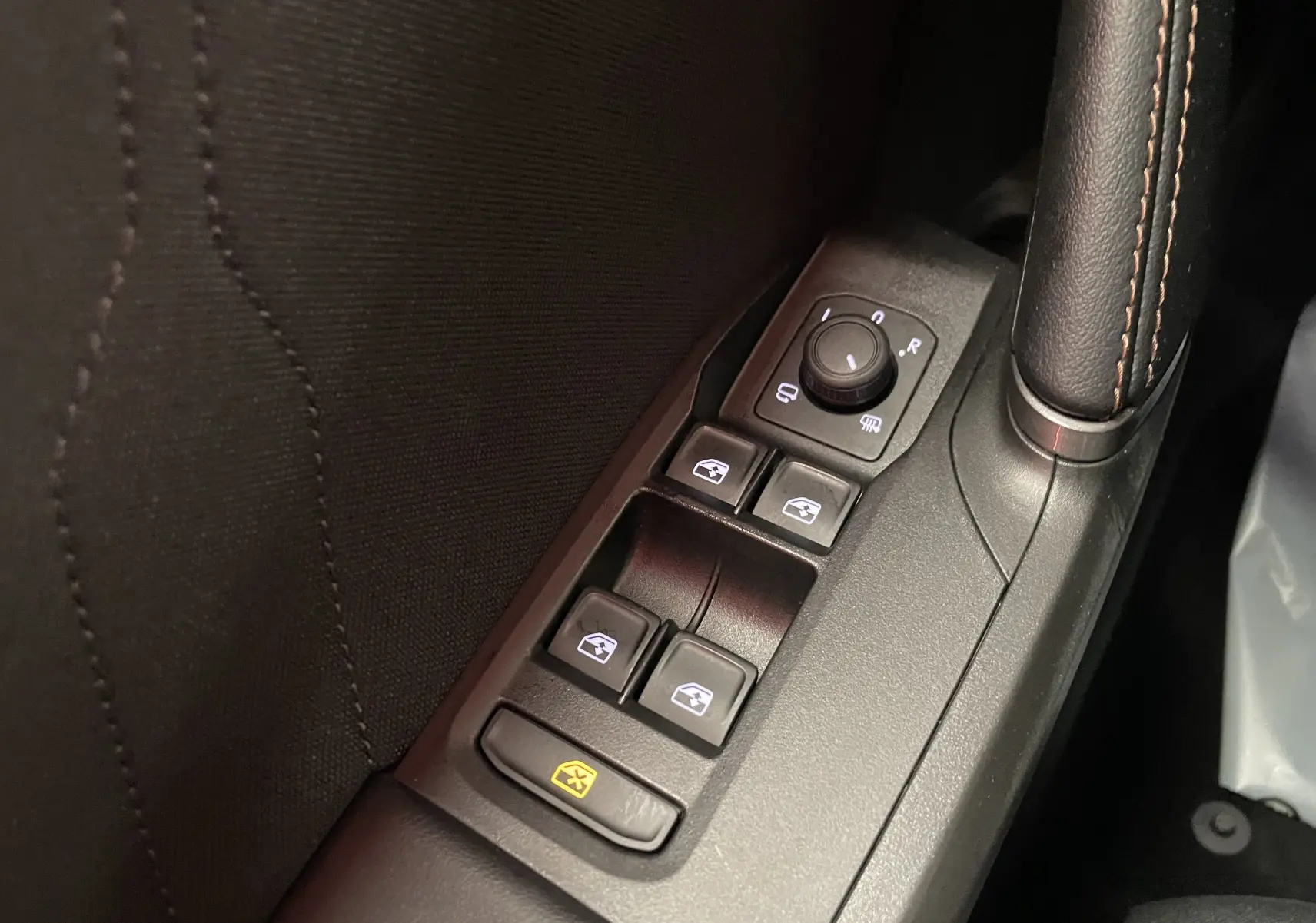 Gros plan sur les commandes des vitres et rétroviseurs côté conducteur d'un CUPRA Formentor Noir Minuit 2025.