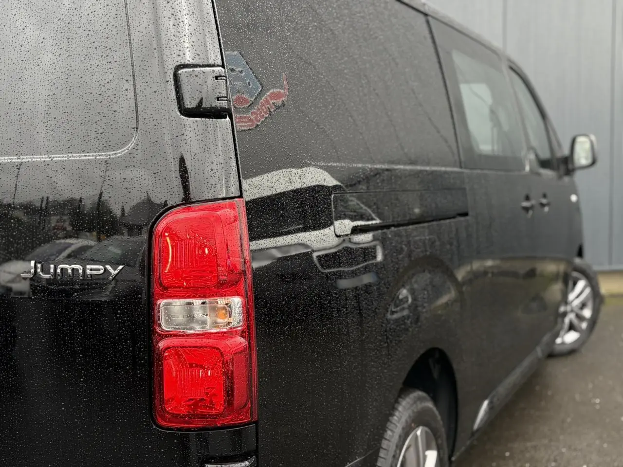 Vue 3/4 arrière droite d’un Citroën Jumpy XL noir Perla avec feux arrière rouges et jantes alliage 17 pouces.