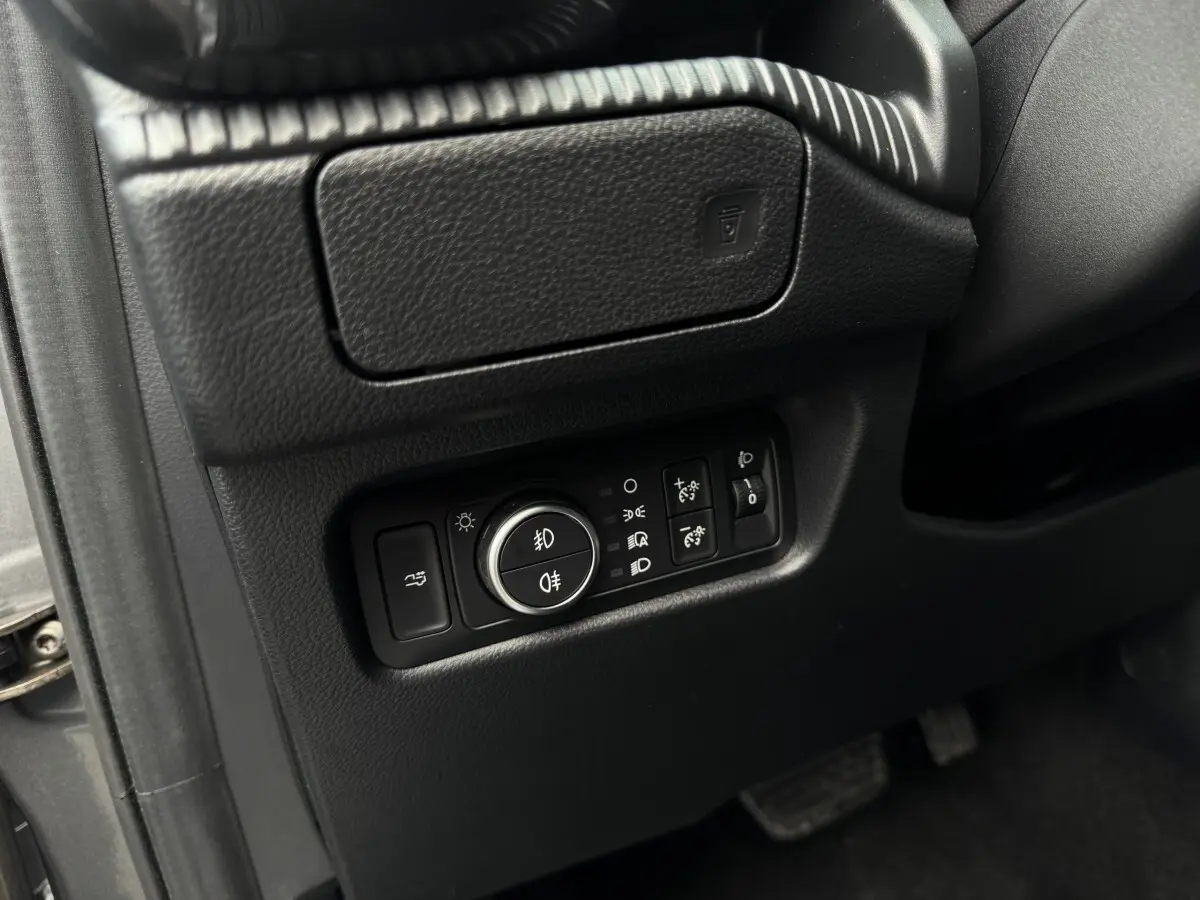 Gros plan sur les commandes d’éclairage noires à gauche du volant dans l’habitacle du Ford Ranger 2025.