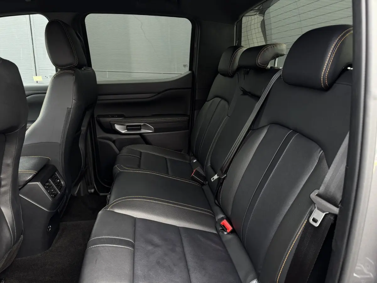 Vue intérieure côté droit des sièges arrière noirs en cuir avec surpiqûres contrastantes du Ford Ranger Wildtrak 2025.