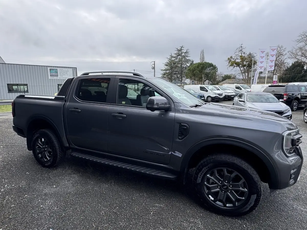 Ford Ranger 2025 gris foncé vu de profil côté gauche, avec jantes noires et double cabine WILDTRAK.