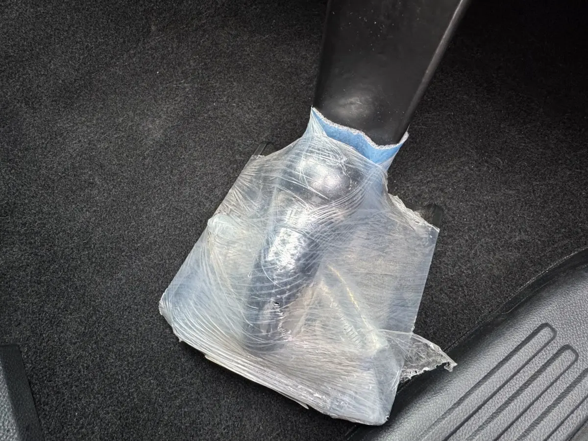 Détail du levier de frein à main noir partiellement protégé par un film plastique transparent dans un Ford Ranger.