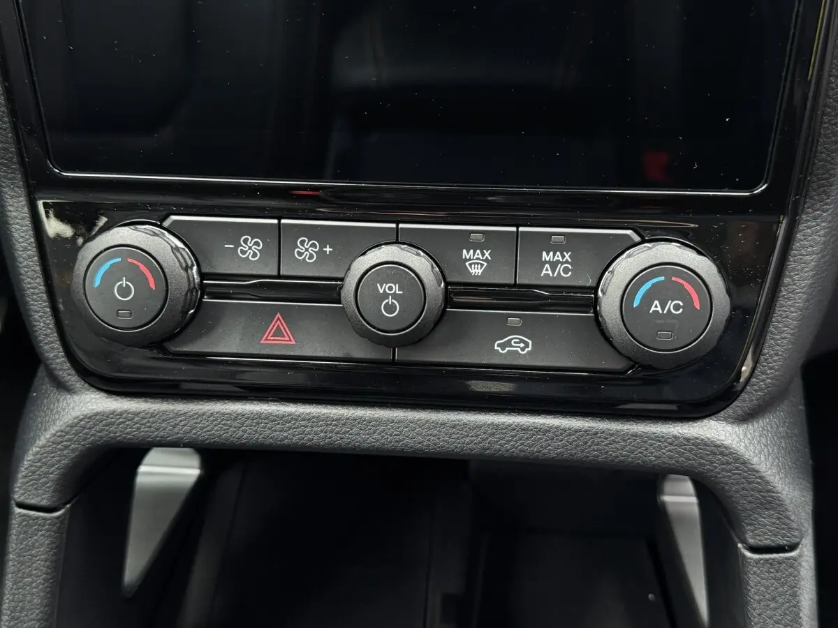 Gros plan sur la console centrale noire du Ford Ranger 2025, avec commandes climatisation et volume visibles.