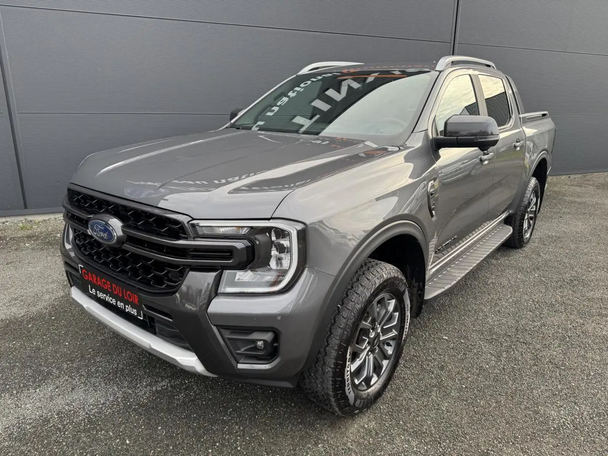 Ford Ranger 2025 gris vue 3/4 avant droit, avec calandre noire et marchepieds latéraux en aluminium.