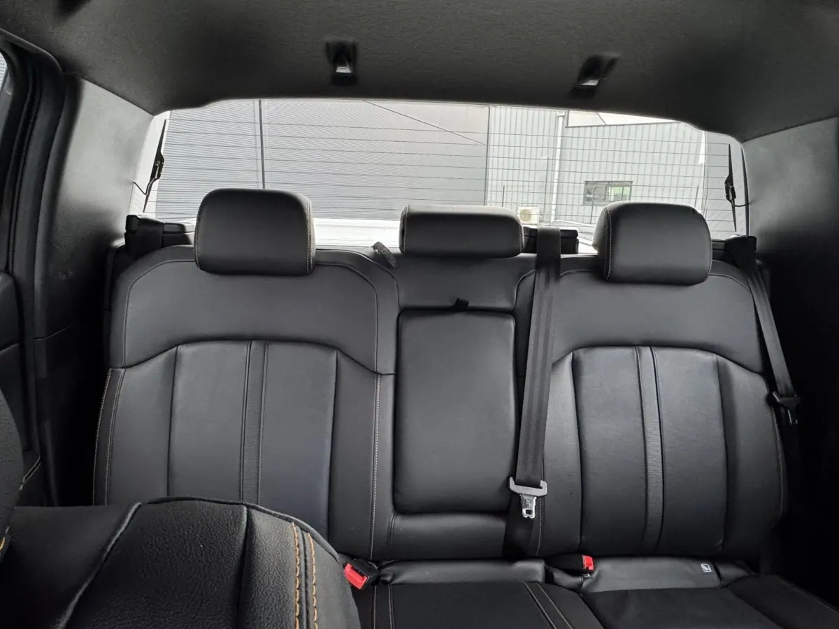 Vue intérieure arrière du Ford Ranger 2025, sièges en cuir noir avec surpiqûres contrastantes et ceinture de sécurité visible.