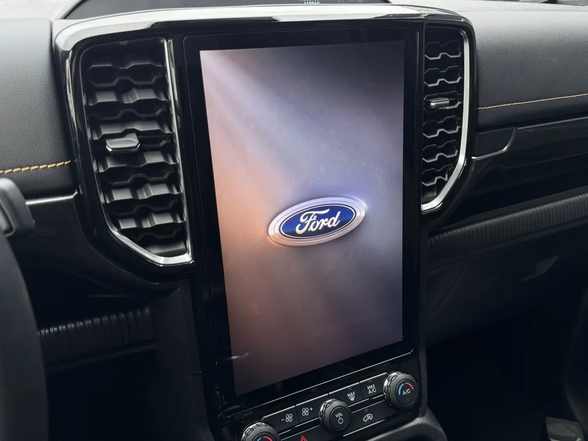Vue rapprochée du tableau de bord noir du Ford Ranger 2025 avec grand écran tactile vertical affichant le logo Ford.