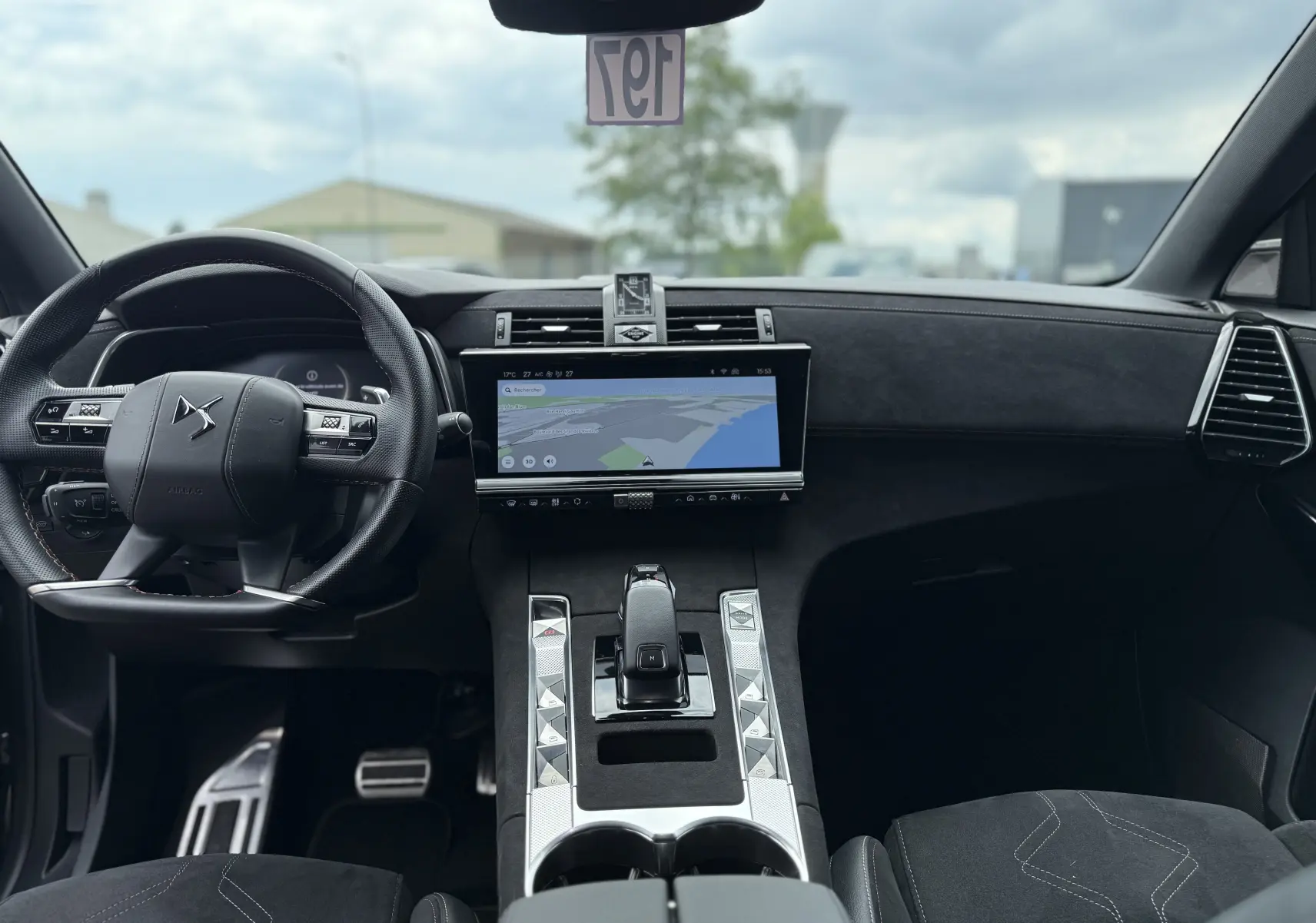 Vue intérieure avant du DS7 BlueHDi 130 Pallas 2025, tableau de bord noir avec écran tactile et volant multifonction.
