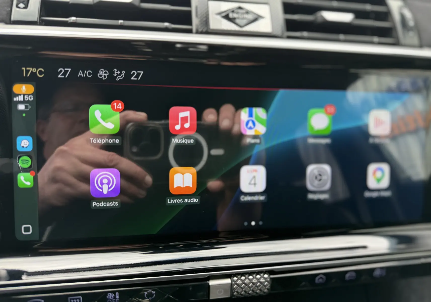 Écran tactile central du DS7 2025 affichant les applications Apple CarPlay avec commandes climatisation visibles en dessous.
