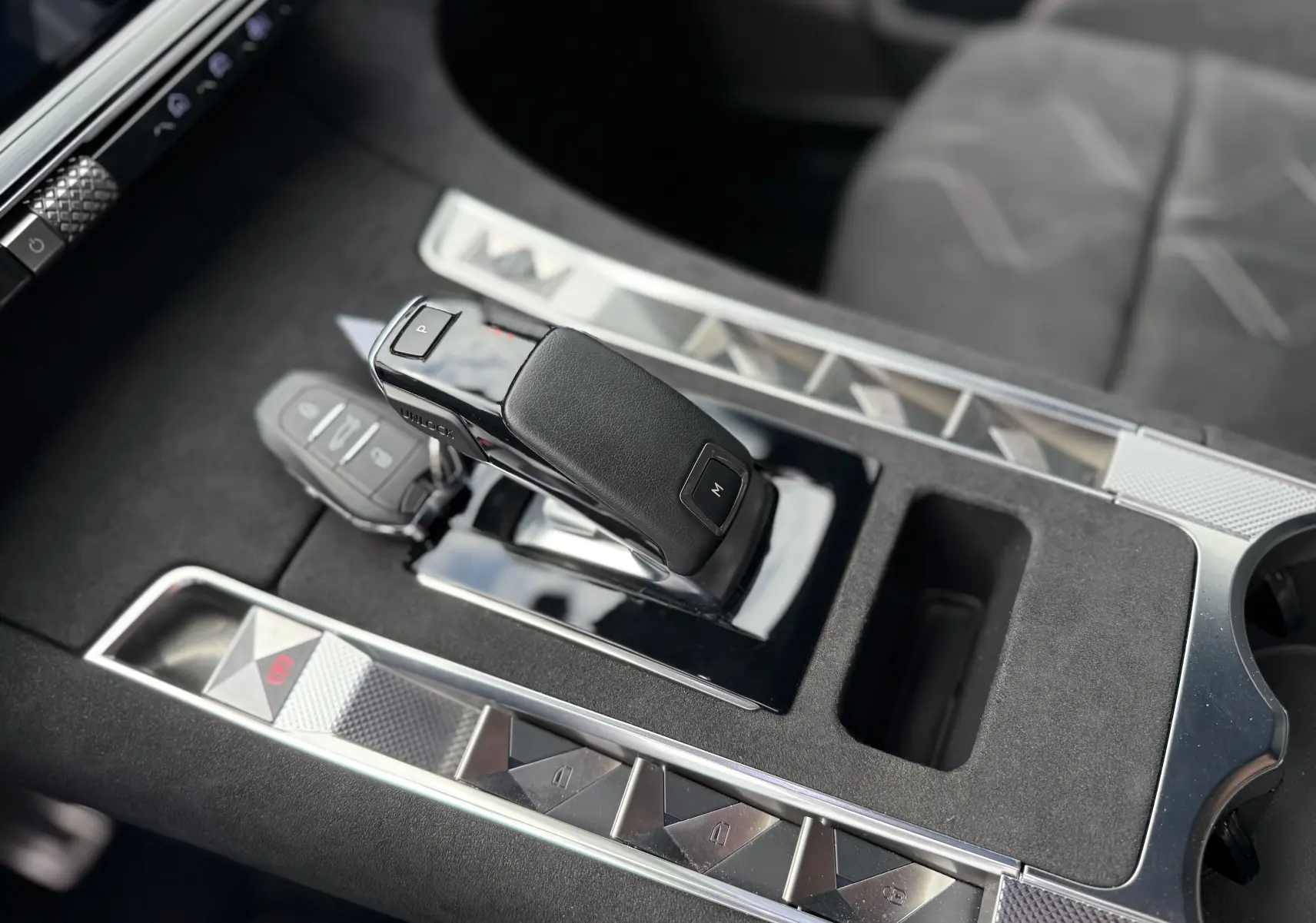 Gros plan sur la console centrale du DS7 BlueHDi 130 Pallas, avec levier de vitesse automatique et finitions en alcantara gris.