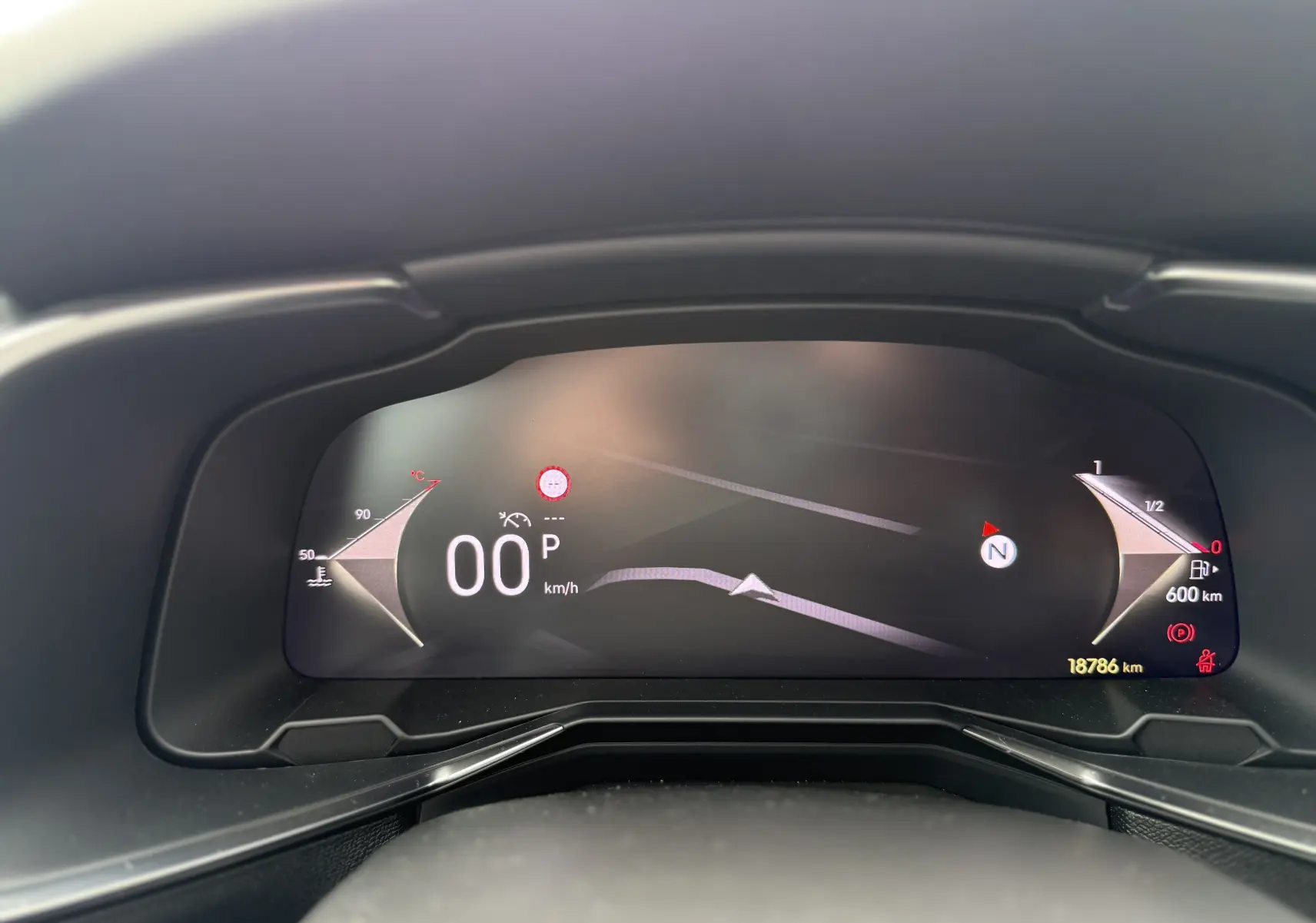 Vue rapprochée du tableau de bord numérique du DS7 2025, affichant la vitesse à 0 km/h et l'autonomie restante.