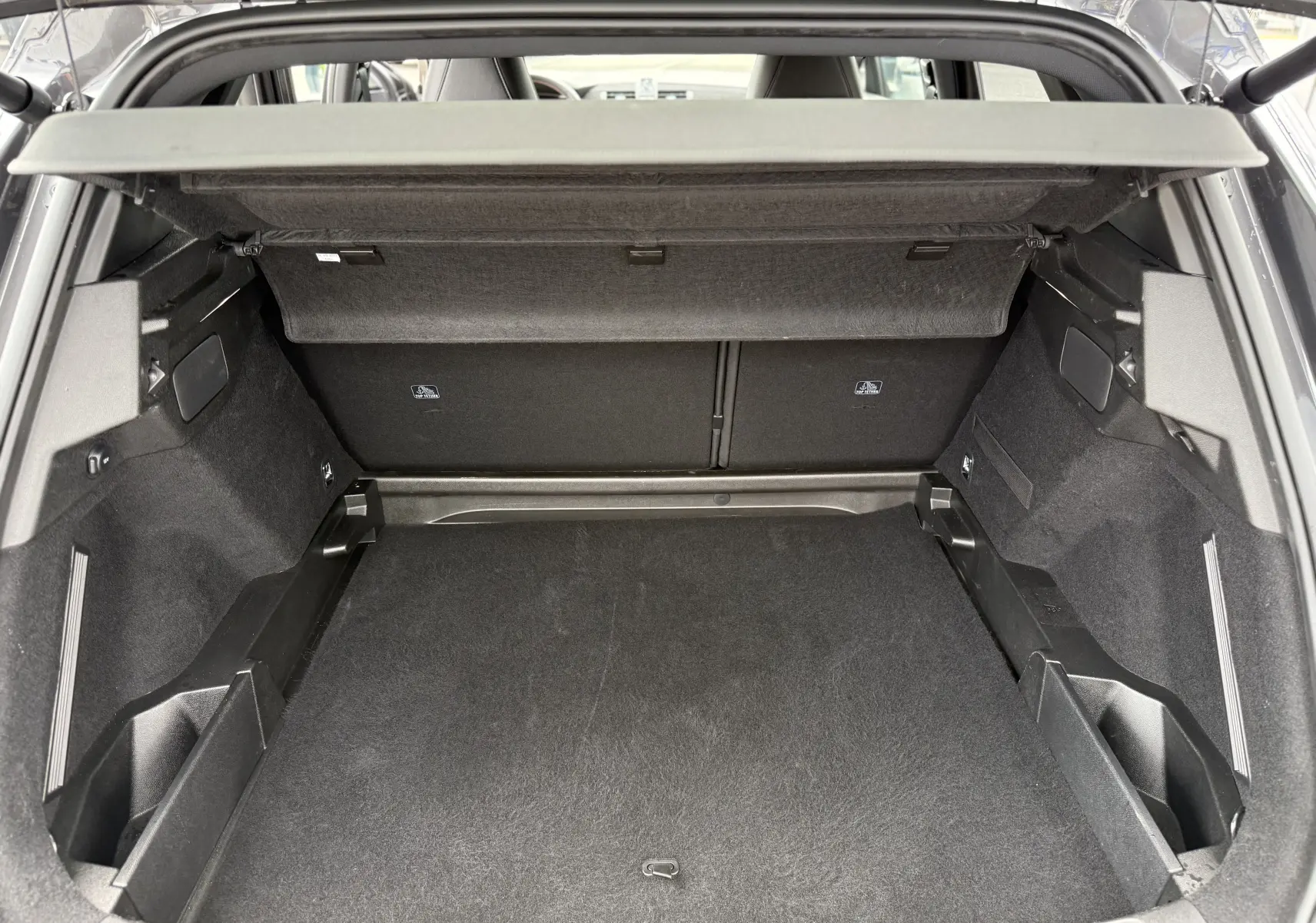 Coffre ouvert vu de l'arrière du DS7 gris titane, montrant un espace de chargement propre et bien agencé.
