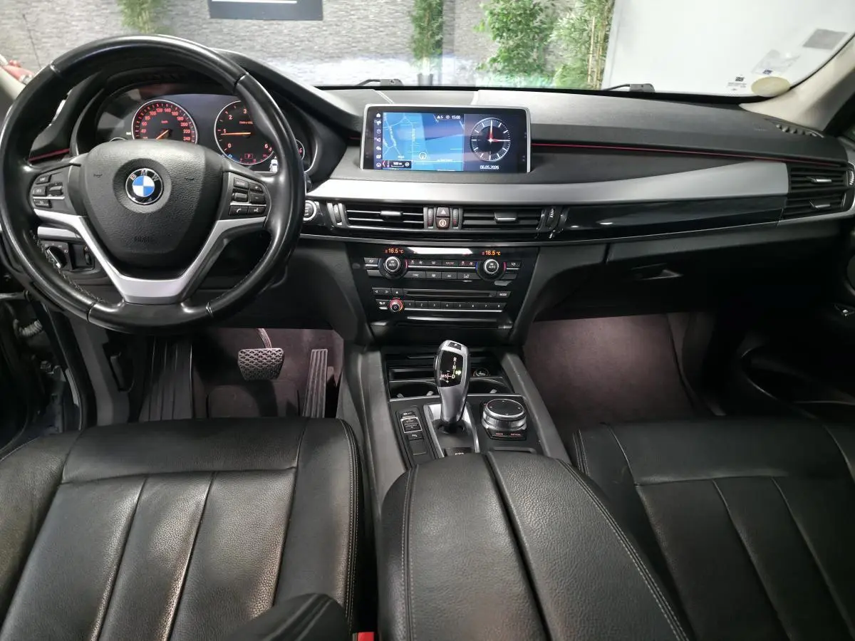 Vue intérieure avant du BMW X5 sDrive 25d 2018 avec sellerie cuir noire et écran de navigation central.