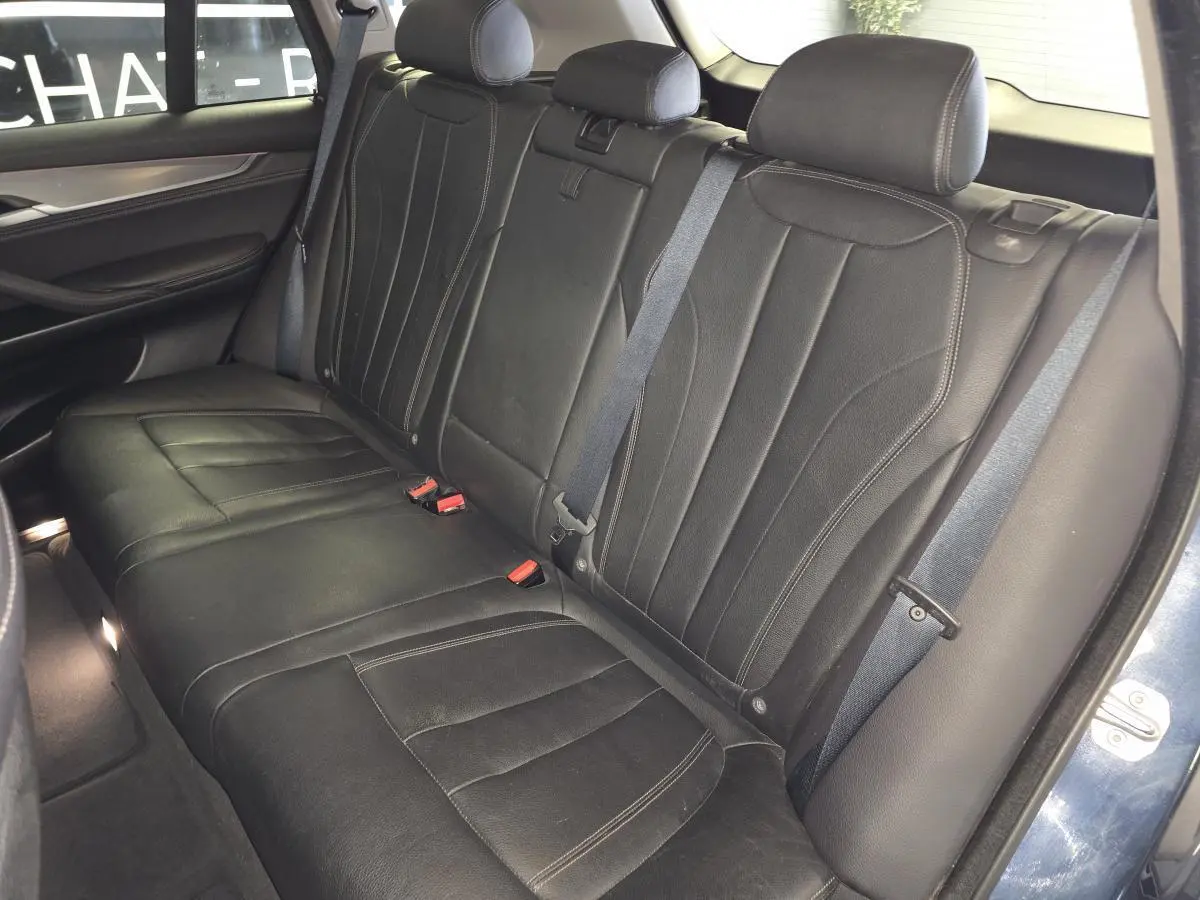 Vue intérieure des sièges arrière en cuir noir du BMW X5 sDrive 25d 2018, avec ceintures de sécurité visibles.