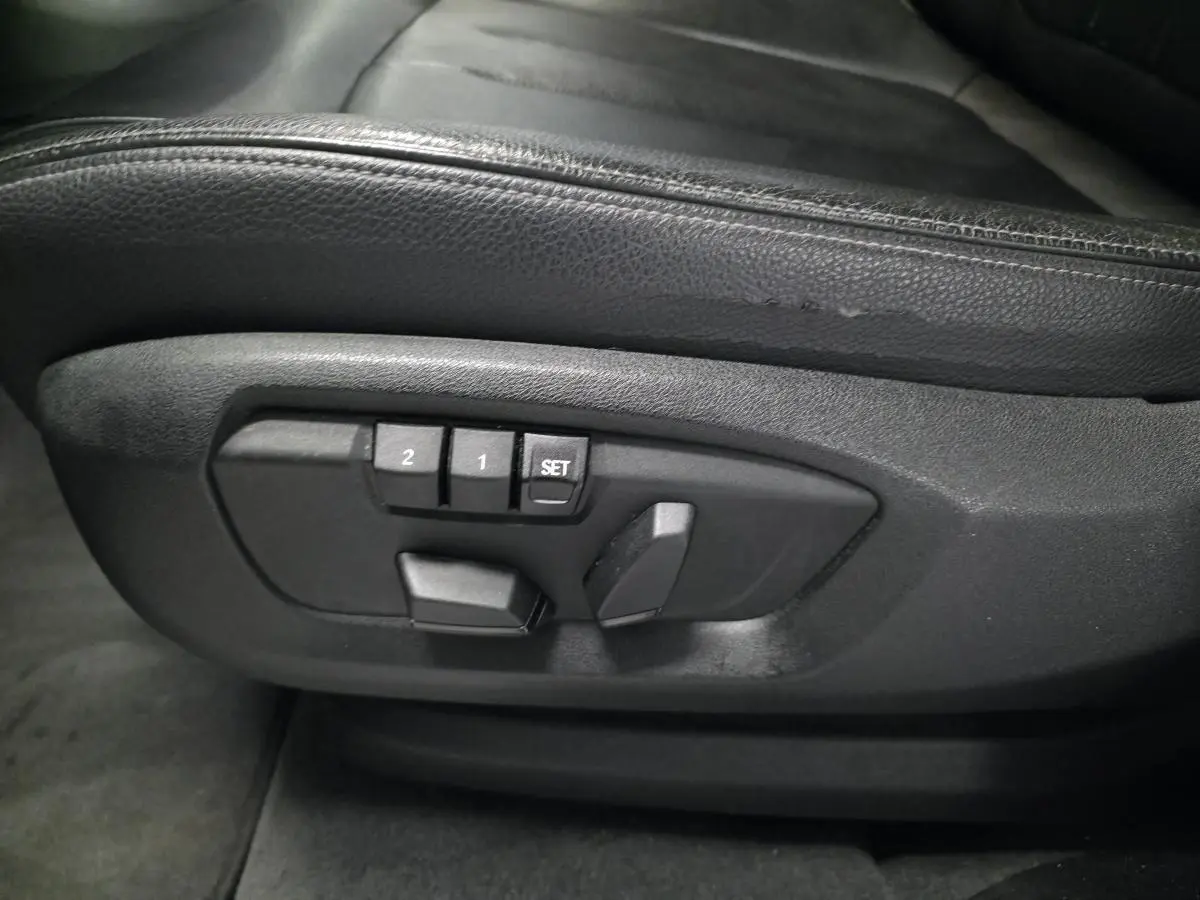 Détail des commandes de réglage électrique des sièges en cuir noir dans un BMW X5 sDrive 25d 2018.
