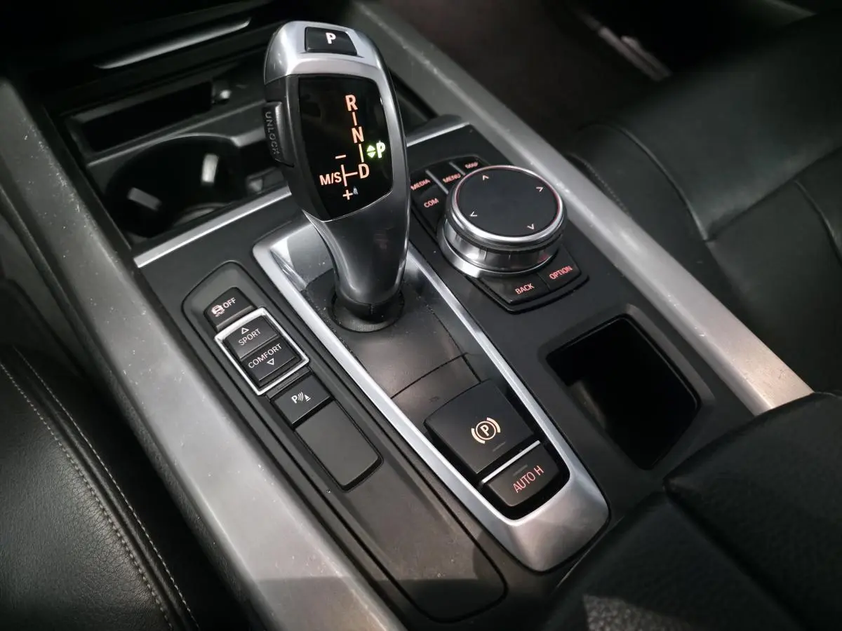 Vue rapprochée de la console centrale avec levier de vitesses automatique et commandes du BMW X5 sDrive 25d bleu.