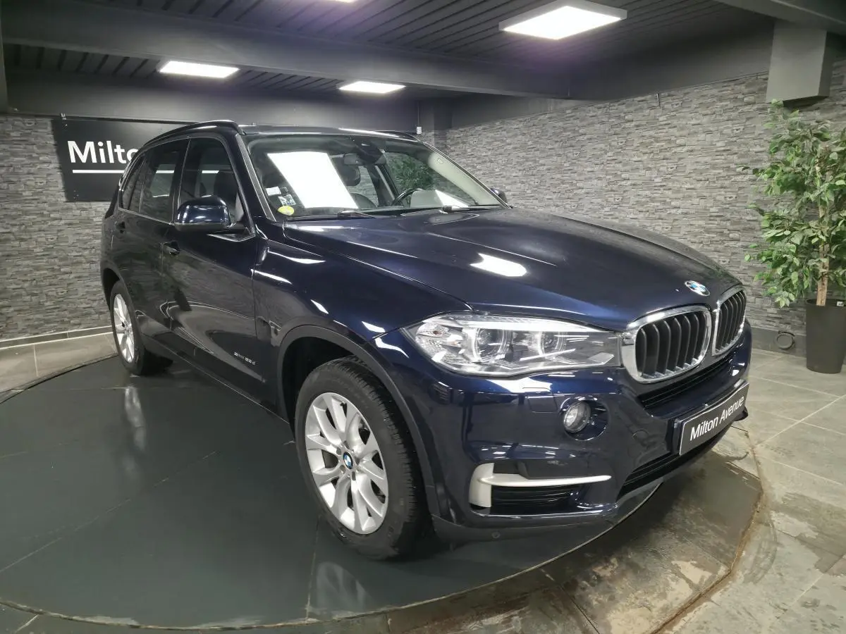 BMW X5 sDrive 25d bleu métallisé vue 3/4 avant droit avec jantes alliage 19'' et calandre chromée.