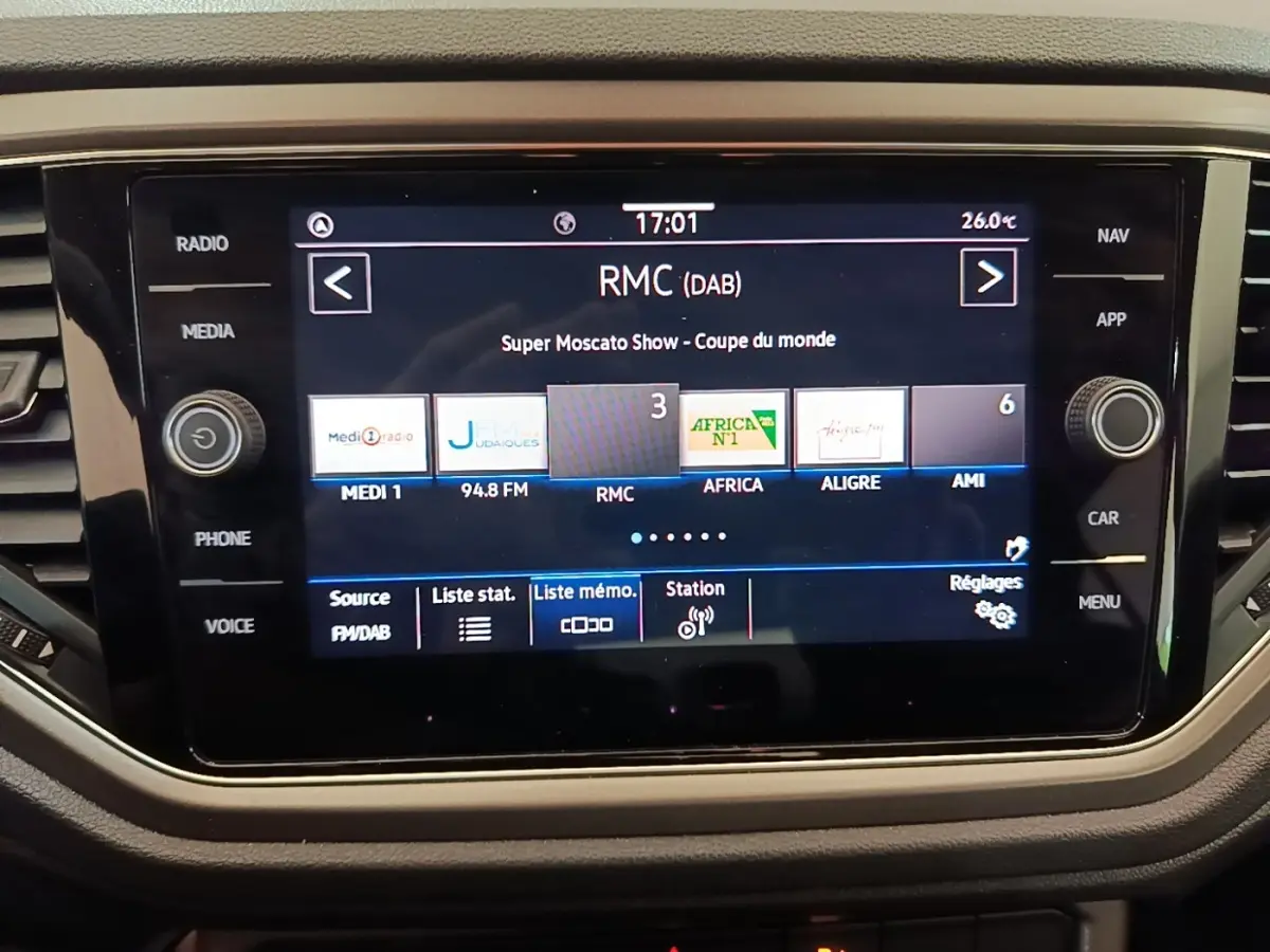 Écran tactile central du Volkswagen T-Roc 1.5 TSI bleu, affichant les stations radio avec interface moderne.