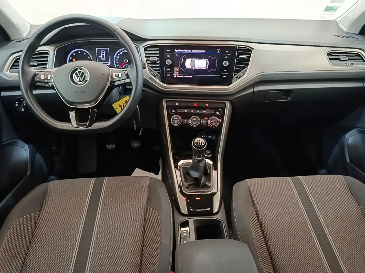 Vue intérieure frontale du Volkswagen T-Roc 1.5 TSI 2020, tableau de bord noir avec écran tactile et boîte manuelle.