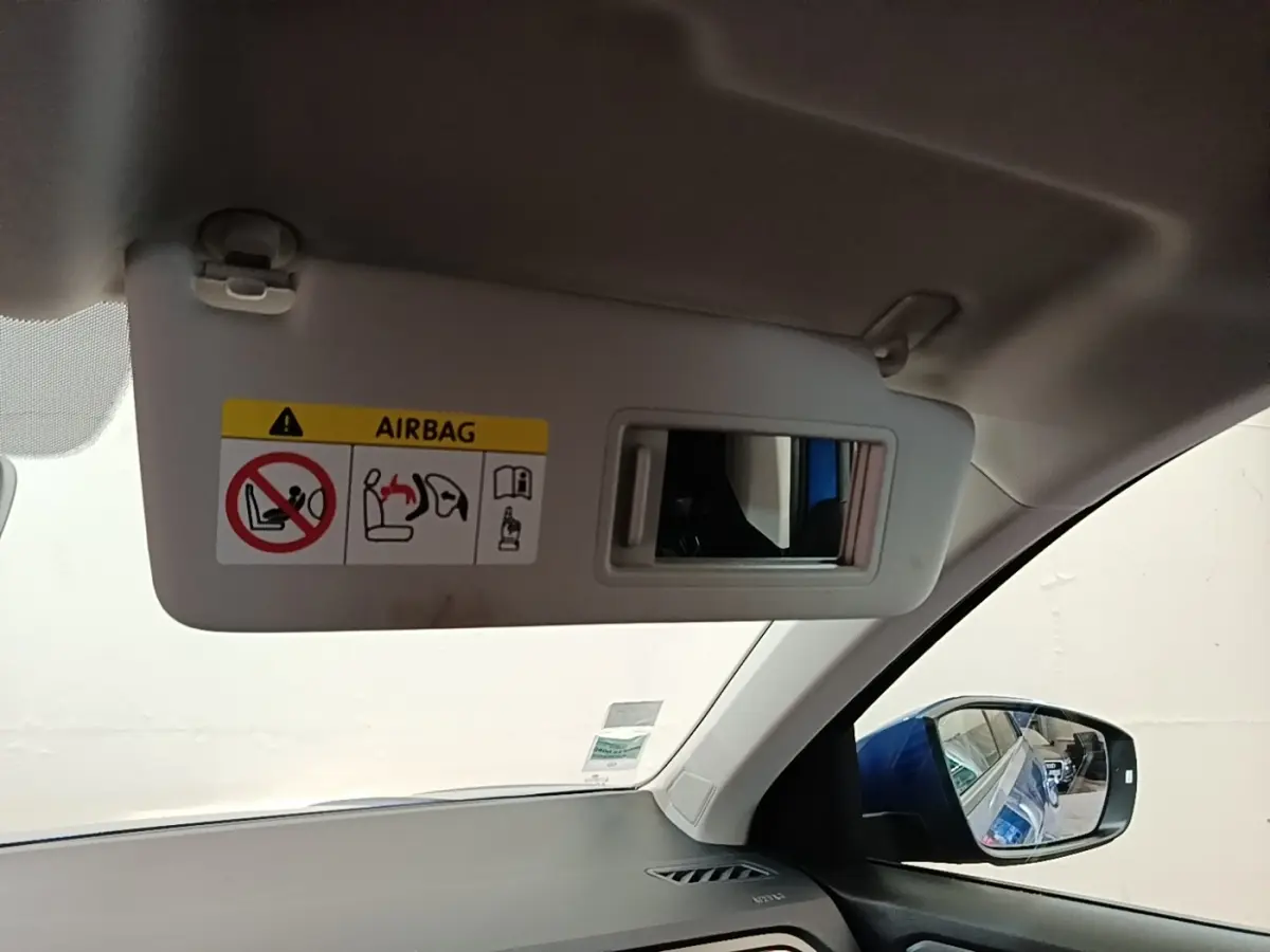 Intérieur du Volkswagen T-Roc bleu 2020, vue sur pare-soleil avec miroir et rétroviseur latéral droit.
