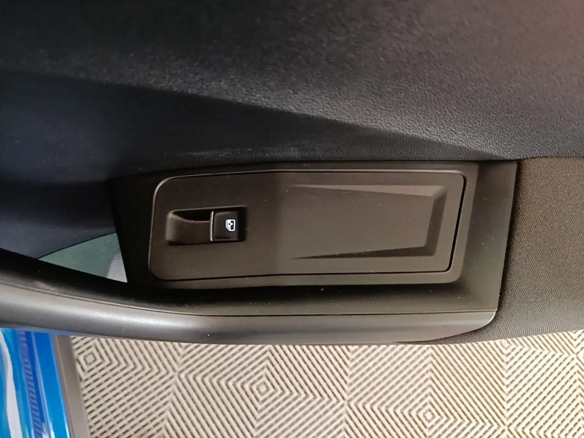 Détail de la commande de lève-vitre sur la porte intérieure côté conducteur d’un Volkswagen T-Roc bleu 2020.