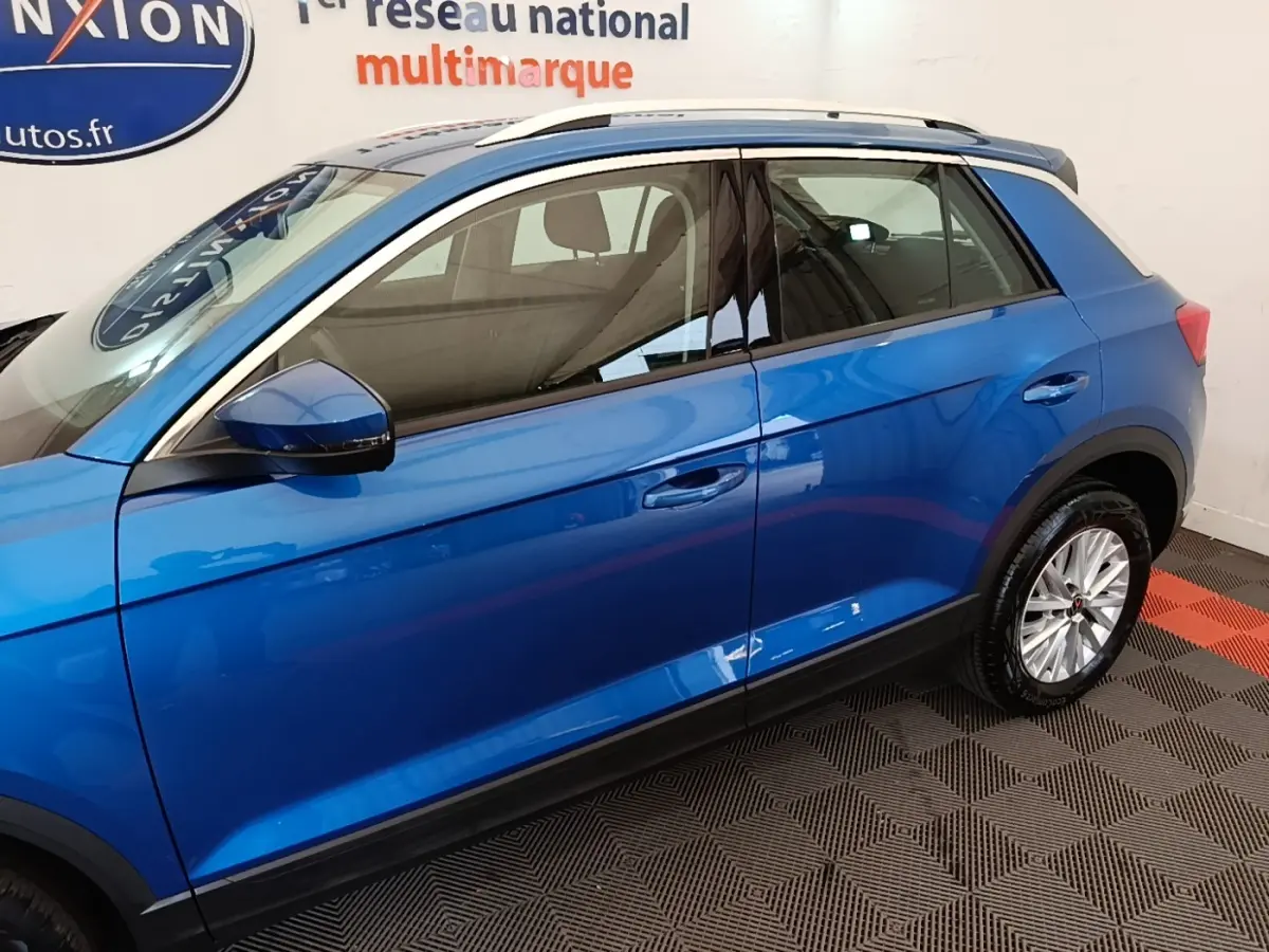 Vue latérale gauche d'un Volkswagen T-Roc bleu 2020 avec jantes alliage et rétroviseurs assortis.