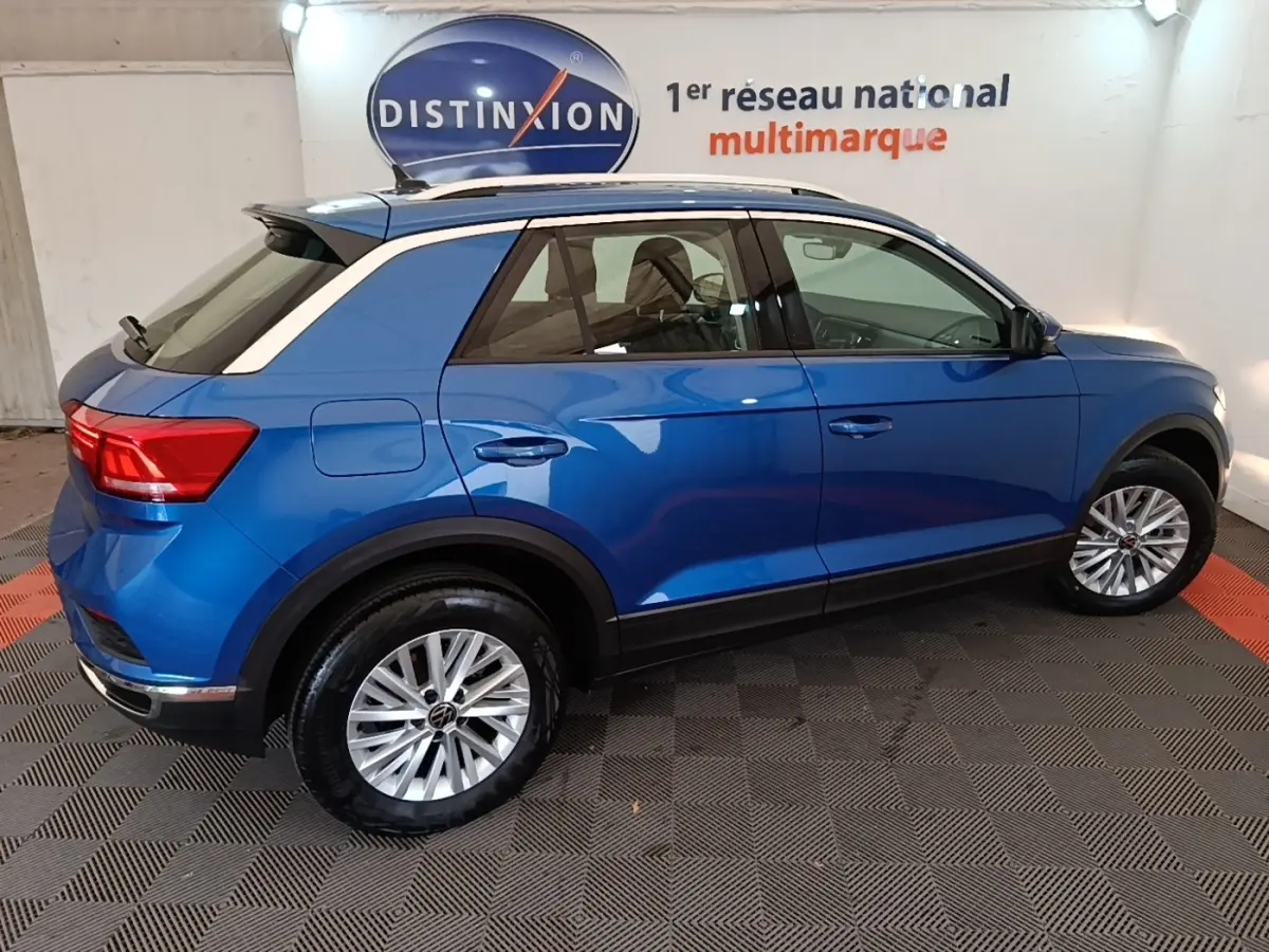 Vue latérale droite d'un Volkswagen T-Roc bleu 2020 avec jantes alliage et toit blanc contrasté.