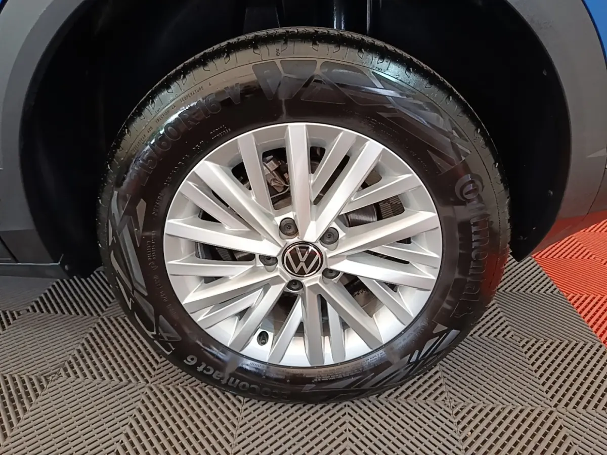 Gros plan sur la roue avant droite d’un Volkswagen T-Roc bleu, avec jante alliage argentée et pneu Continental.