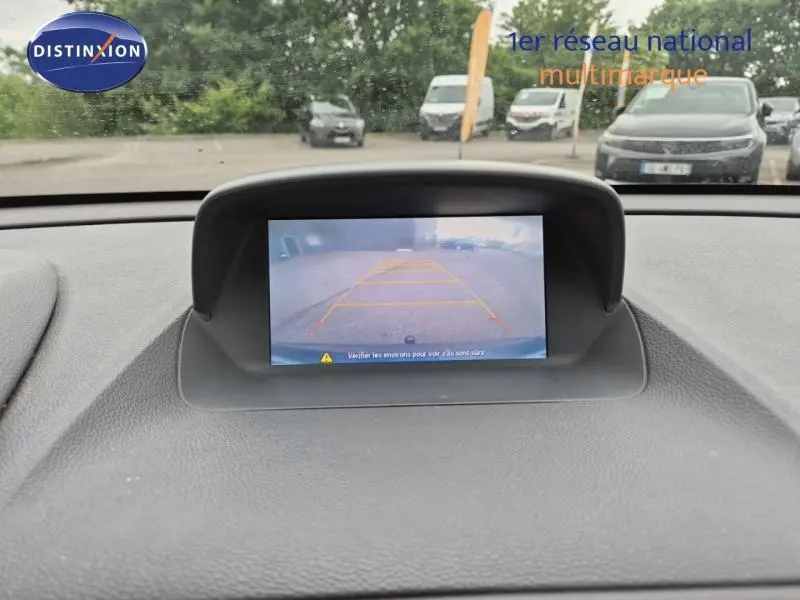 Vue intérieure du tableau de bord d'un Opel Mokka bleu outremer de 2015, écran affichant la caméra de recul.